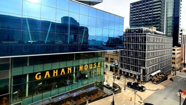 Un edificio moderno con fachada de vidrio y el nombre "GAHAN HOUSE" bien visible.