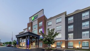 Un hotel con diseño moderno, destacando un letrero grande del Hampton Inn Express Suites.