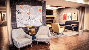 A modern lobby with two armchairs, a sofa, a fireplace, and a map mural. - Holiday Inn Express Hotel & Suites Douglas by IHG (Douglas)