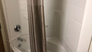 A shower area with a glass door, a bathtub, and a faucet. - Motel 6 Avoca, IA (Avoca)