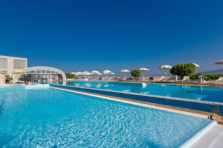 Una piscina al aire libre de temporada, sombrillas