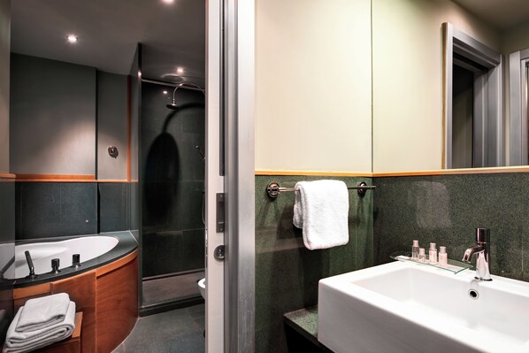 A modern bathroom with a large sink, a glass shower enclosure, and a mirror above the sink.