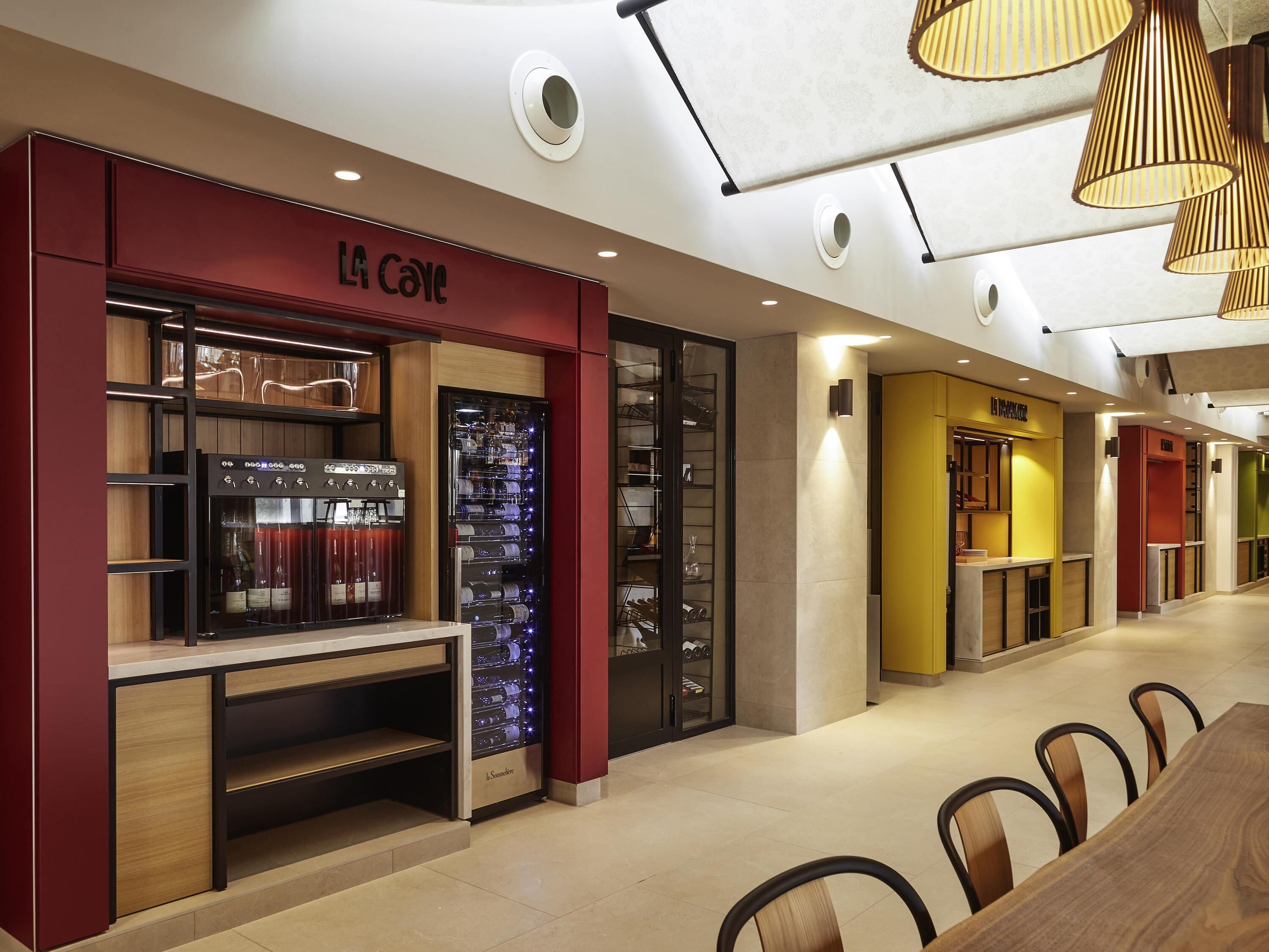Un intérieur moderne comprenant un réfrigérateur à vin, un coin salon et un comptoir.