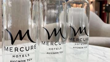 Drie glazen flessen met het label 'Mercure Hotels Avignon TGV' en een gestileerd 'M'-logo.