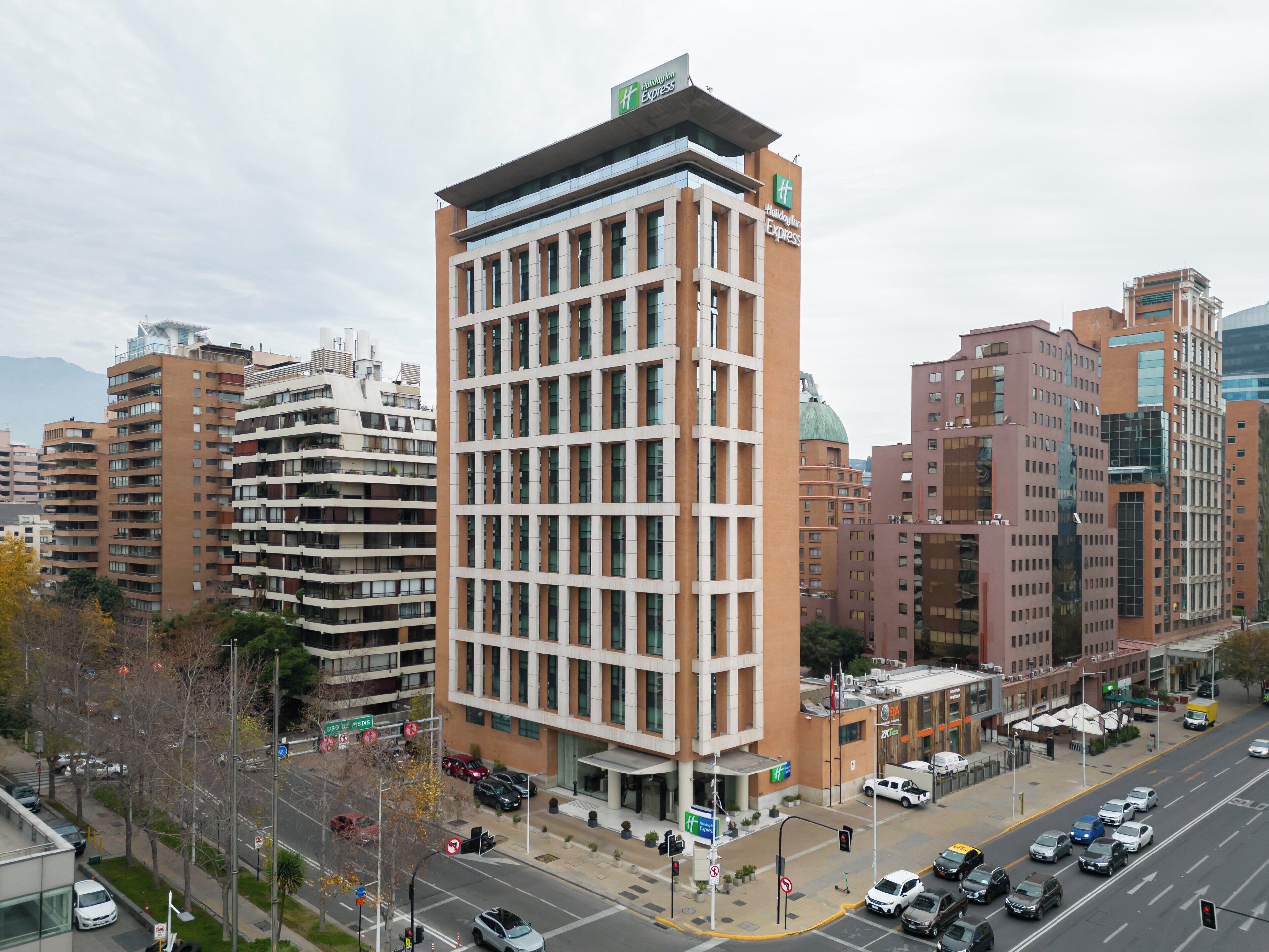 Un hotel moderno con un llamativo letrero de Holiday Inn Express, que presenta una fachada tipo celosía y varios pisos.