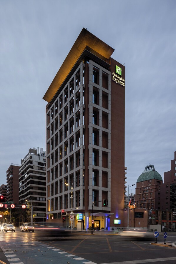 Ein Holiday Inn Express Gebäude mit modernem Design, das einen markanten Eingang und eine große Kuppelstruktur in der Nähe zeigt.