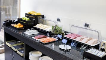Un mostrador de buffet con diferentes alimentos y utensilios.