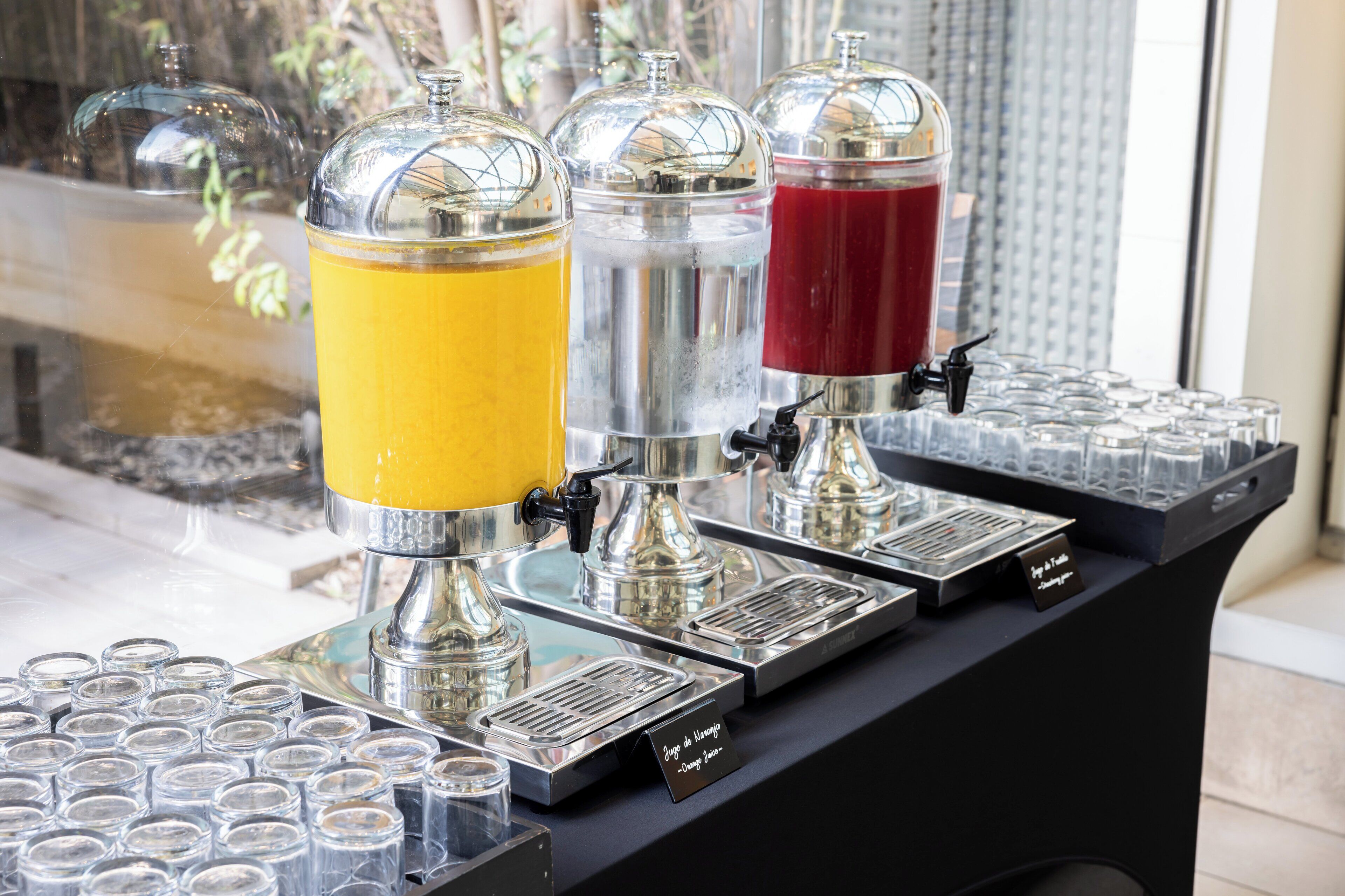 Un distributeur de boissons équipé de trois réservoirs, chacun contenant une boisson d’une couleur différente.
