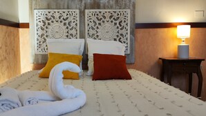A hotel room with a bed, two pillows, a lamp, and a towel. - Hotel San Felice (Bologna)