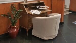 A corner desk with a chair, a vase with a plant, and a candelabra. - Hotel San Felice (Bologna)