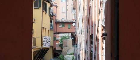 Une ruelle étroite entre deux bâtiments, avec une pancarte indiquant qu’il s’agit d’un site historique.