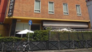 A hotel with a brick facade, multiple windows, and a sign reading "HOTEL GORGIO". - Hotel San Giorgio (Bologna)