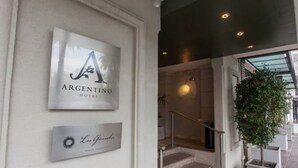 A hotel entrance with a sign for 'Argentino Hotel' and a sign for 'Lo Gran Hotel'. - Argentino Hotel (Mendoza)