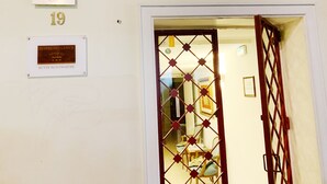 Een hotelingang met een glazen deur, een plaquette die een prijs uit 2017 van het Ministerie van Toerisme vermeldt, en een bord met de tekst Hotel Bellevue in Butte Montmartre.