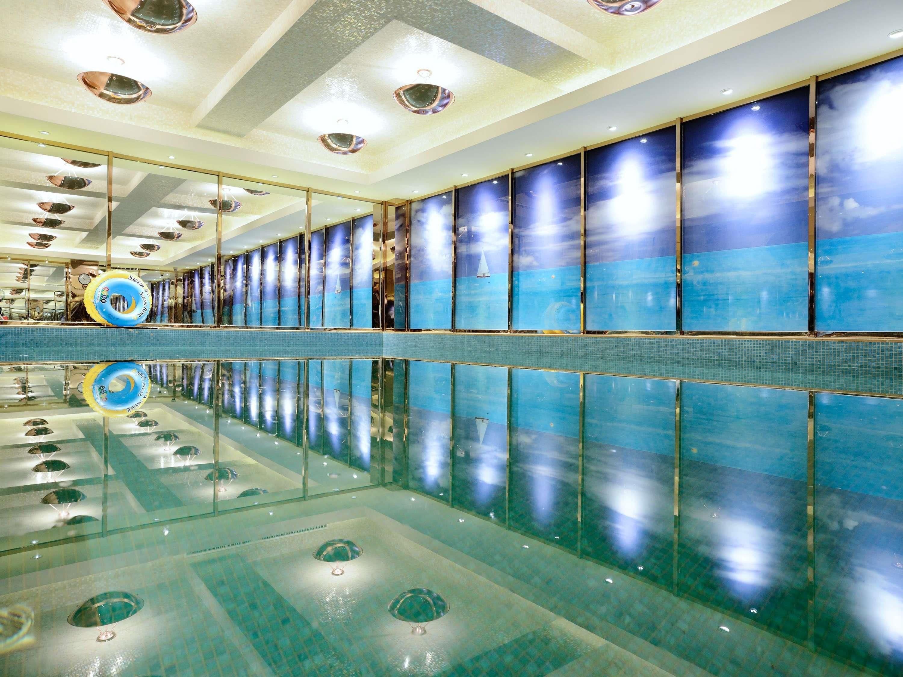 A large indoor swimming pool with clear water, multiple lanes, and overhead lighting.