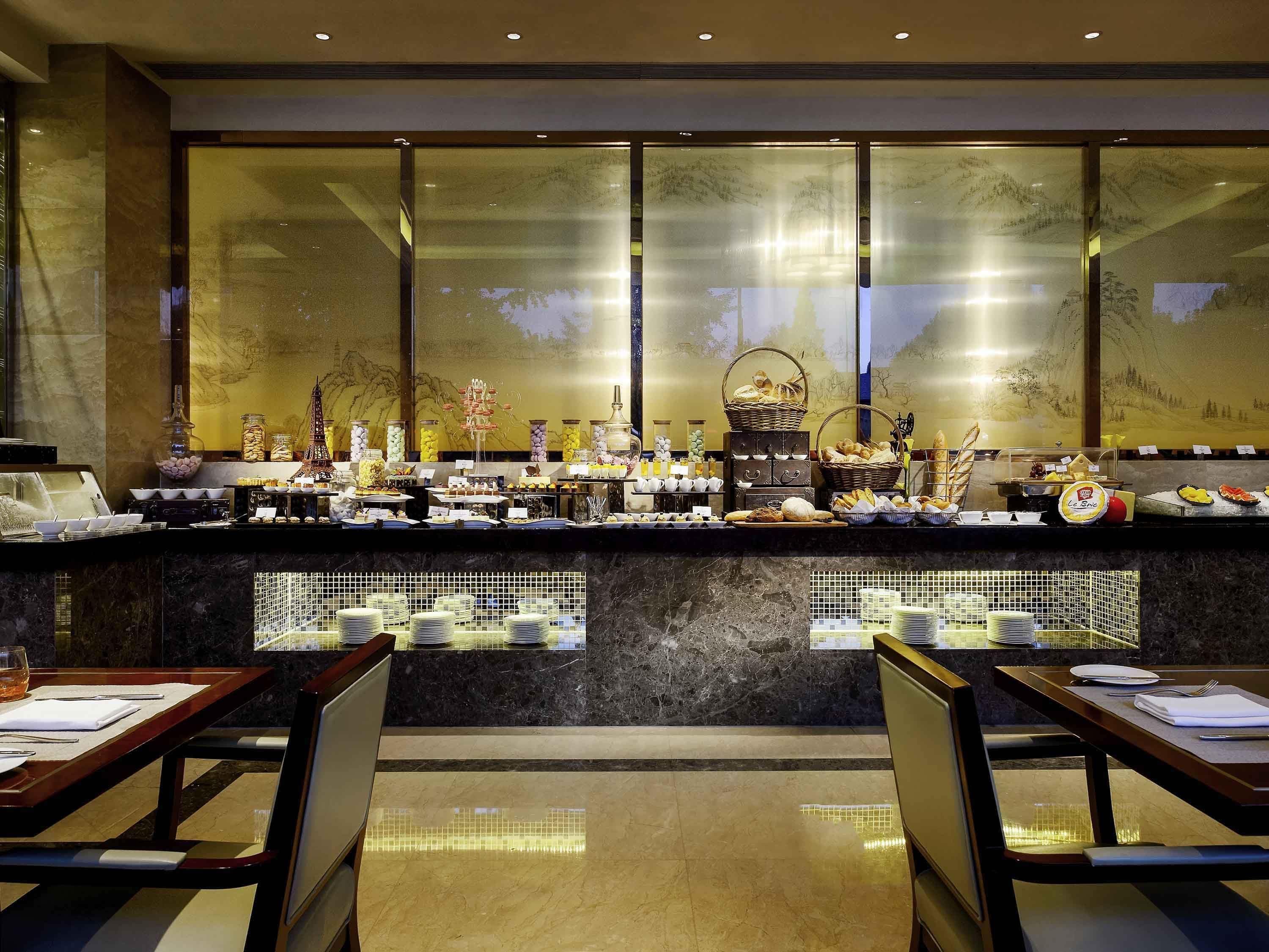 A buffet area with a variety of food items and a seating area with tables and chairs.