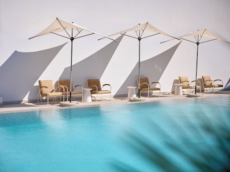 Una piscina al aire libre de temporada, sombrillas