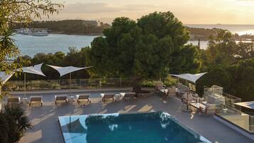 Una piscina al aire libre de temporada, sombrillas