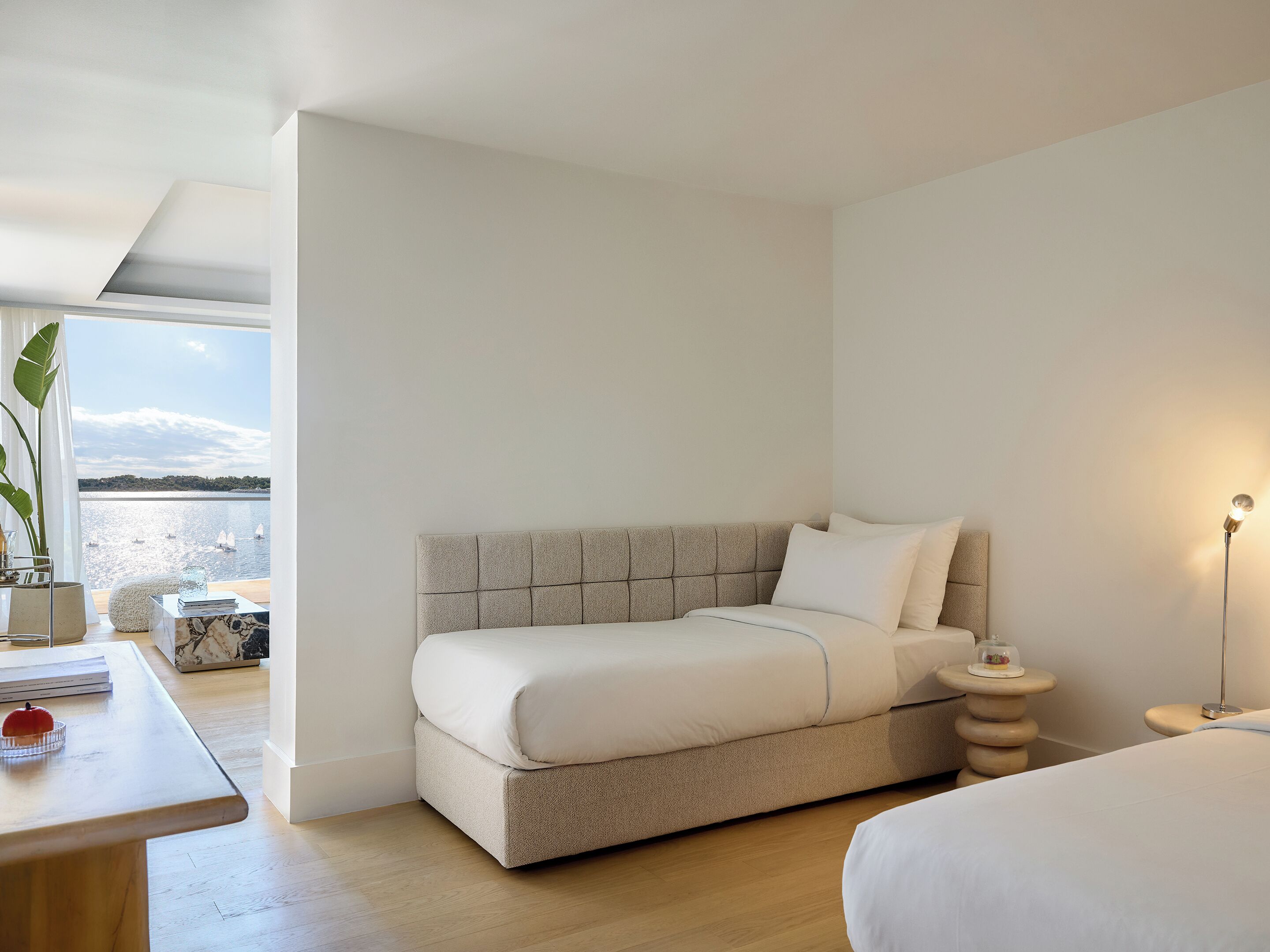 Una camera da letto moderna con un letto, comodino e vista sul mare.
