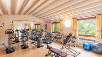 Una palestra con attrezzature per esercizi, una panca, manubri e palle da ginnastica.