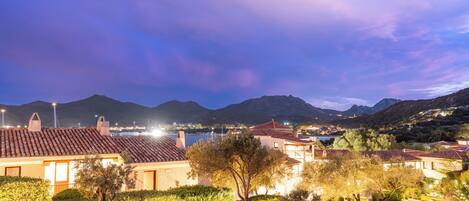 A coastal villa with a tiled roof, stone walls, and a well-maintained garden.