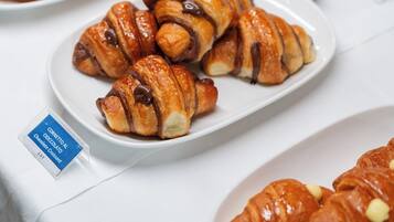 A table with plates of croissants, some with chocolate and others with white chocolate.