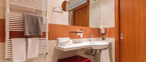 A bathroom with a sink, mirror, towel rack, and a red storage unit.