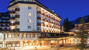 A multi-story hotel with balconies, a sign reading 'ALASKA,' and a covered outdoor area with a Christmas tree.