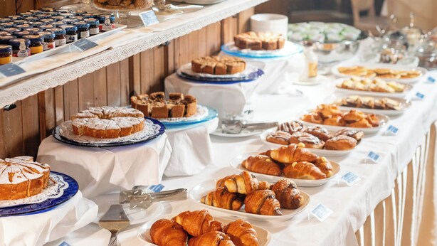 A buffet with various baked goods and pastries.