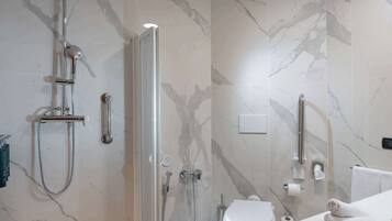 Un baño moderno con ducha de vidrio, inodoro y lavamanos con toalla.