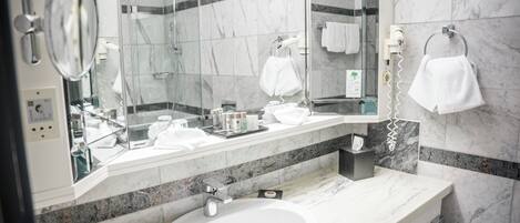 A modern bathroom with a large mirror, a sink, and a towel rack.