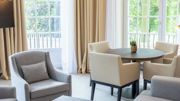 Una sala de estar moderna con una mesa redonda, sillones color beige y un sofá.