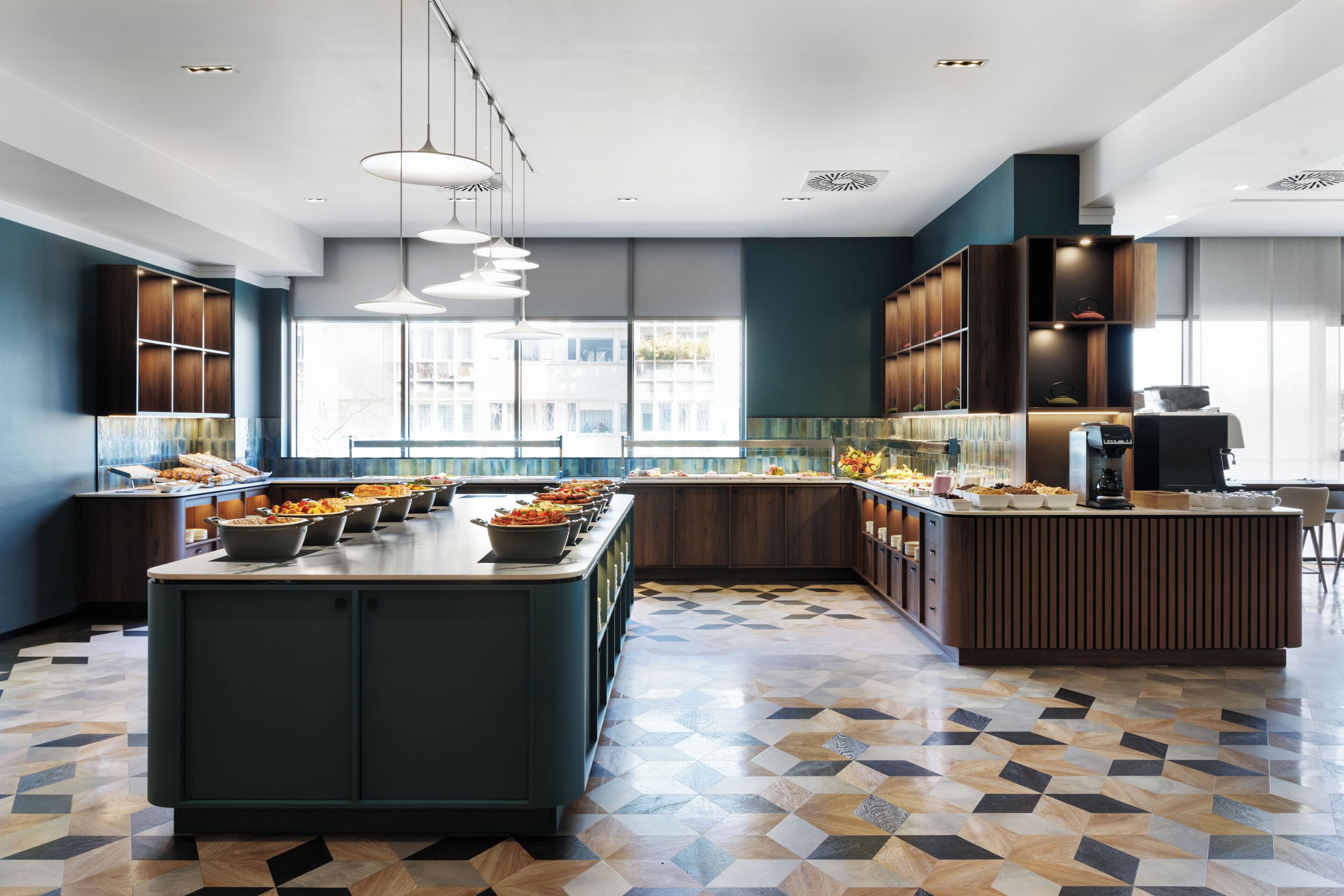A modern kitchen with a central island, built-in cabinetry, pendant lighting, and a geometric patterned floor.