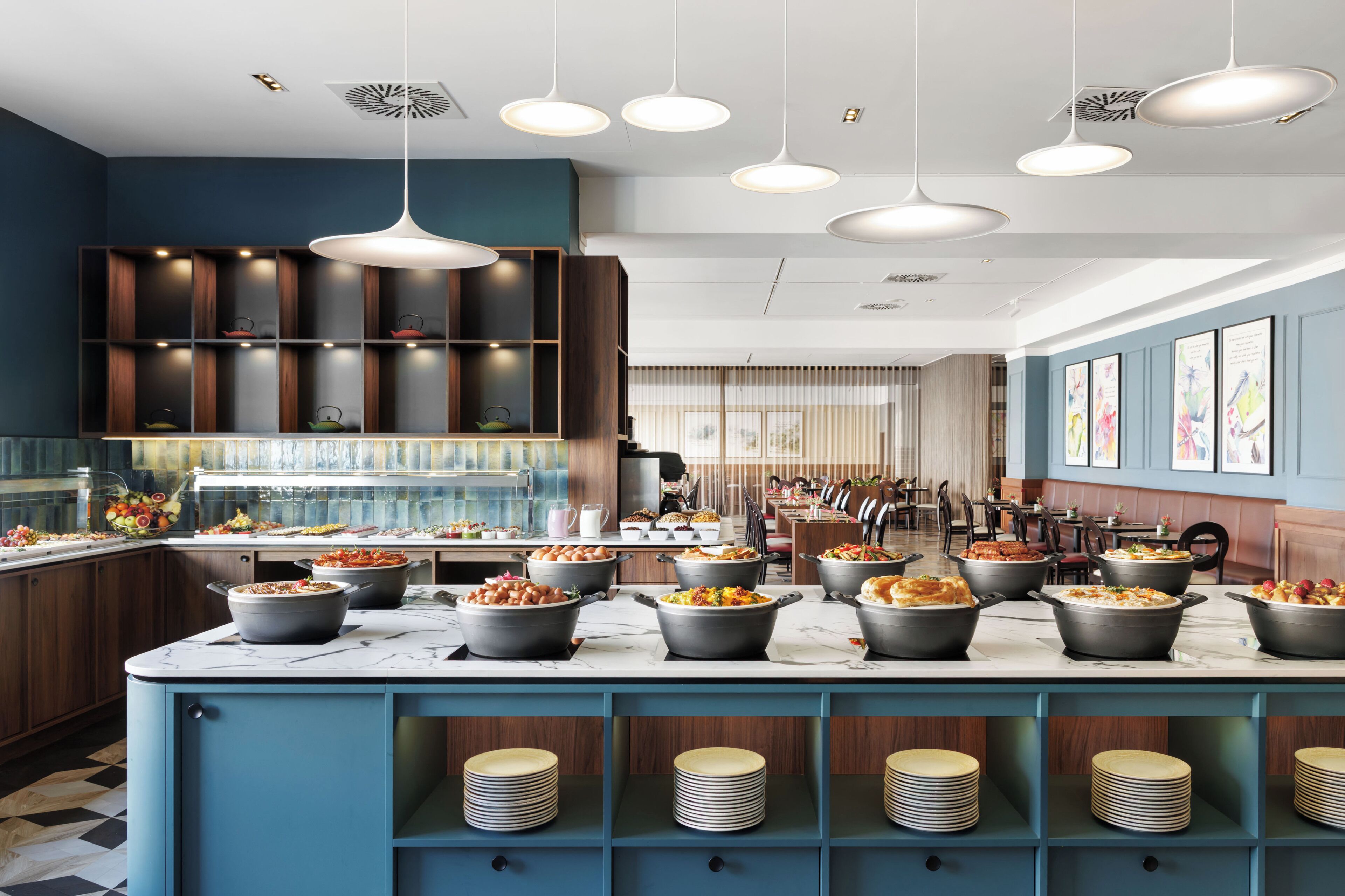 A modern kitchen with multiple serving stations, a marble countertop, and a variety of dishes.