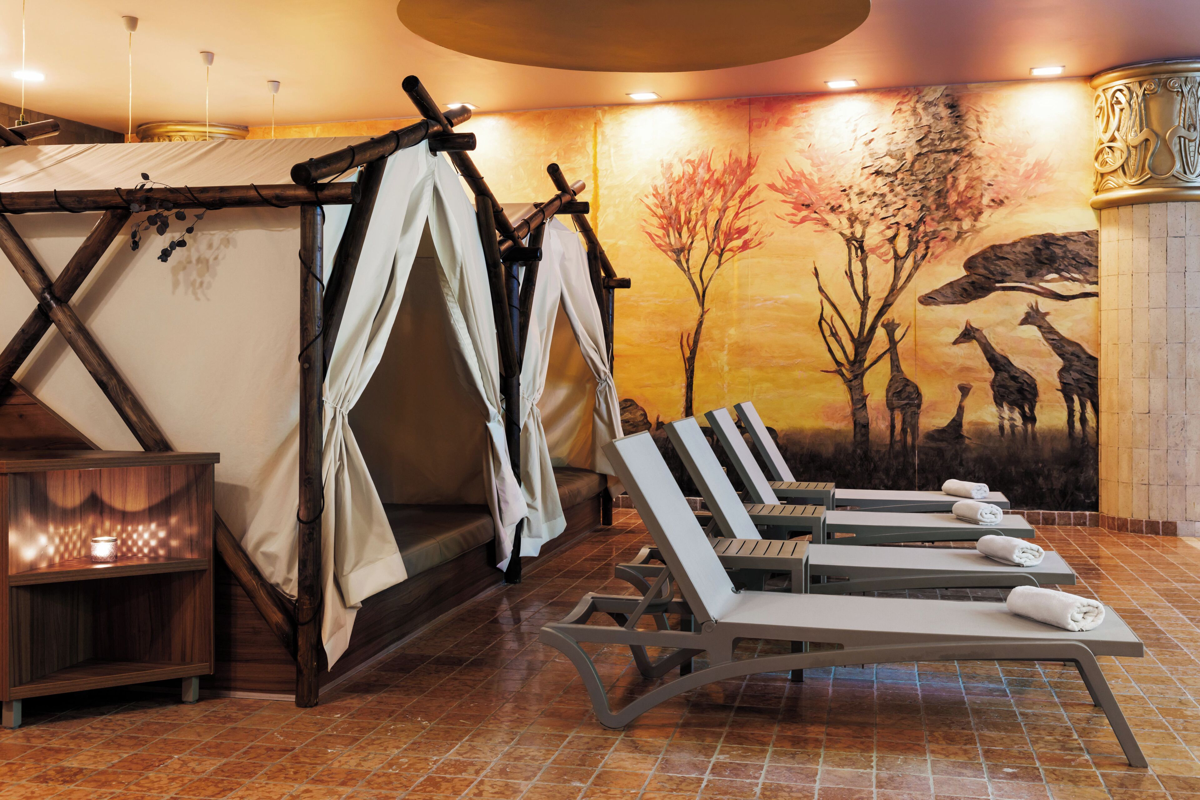 A spa room with a wooden bench area, a tent-like structure, and a mural of giraffes.
