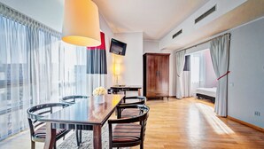A modern hotel room with a dining area, a TV, a wardrobe, and a bed. - Don Prestige Residence (Poznan)
