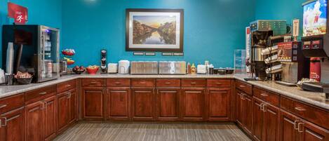 A kitchen with wooden cabinets, a coffee machine, and a microwave.