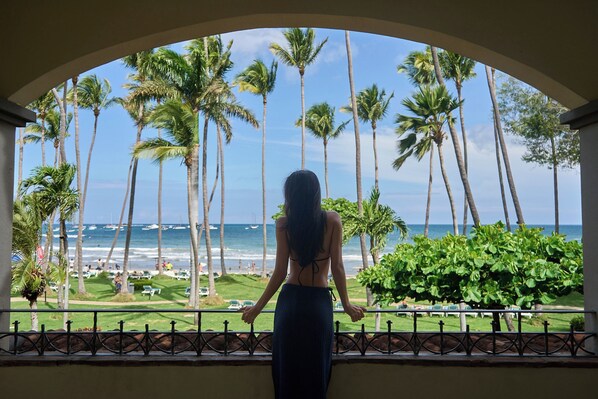 A view from a balcony with a railing, overlooking a beach with palm trees and the ocean. - Hotel Tamarindo Diria Beach Resort (Tamarindo)