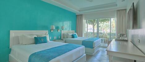 A hotel room with two beds, a desk, and a ceiling fan.