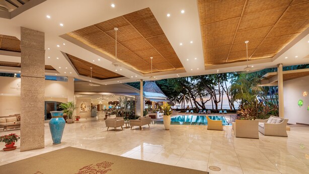 Eine geräumige Lobby mit Schwimmbad, bequemen Sitzgelegenheiten und einer Rezeption.