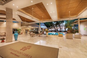 Un hall d’entrée spacieux avec une piscine, des sièges confortables et un espace d’accueil.