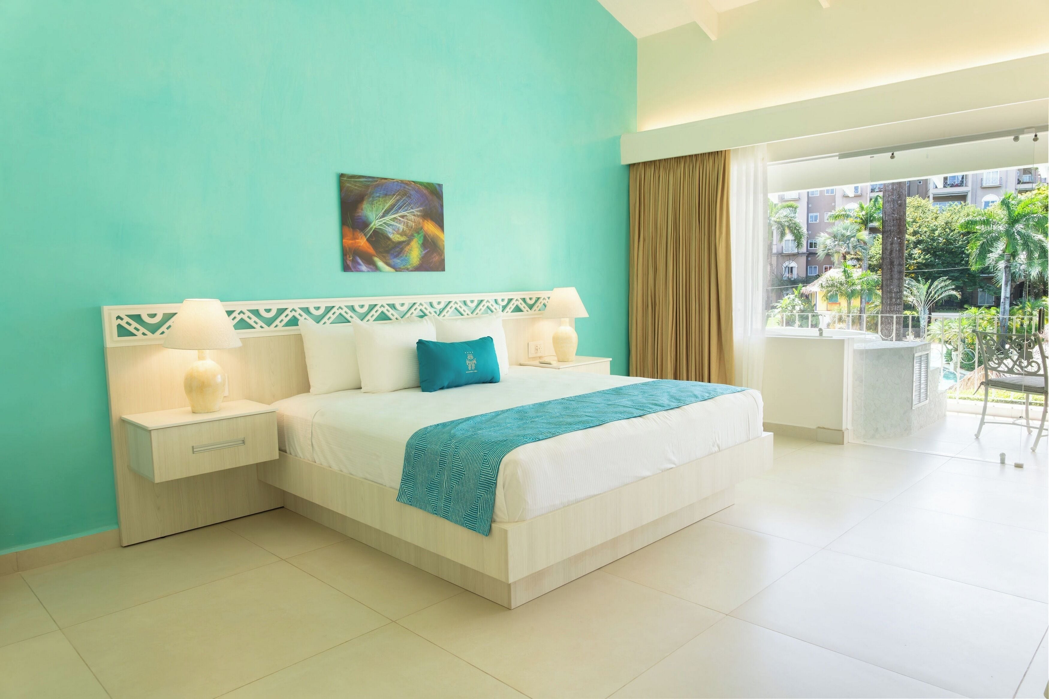 Habitación de hotel con una cama grande, vistas al exterior y un balcón.
