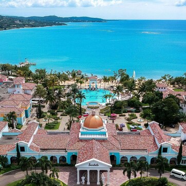A resort with a central pool, a dome-shaped building, and a view of the ocean.