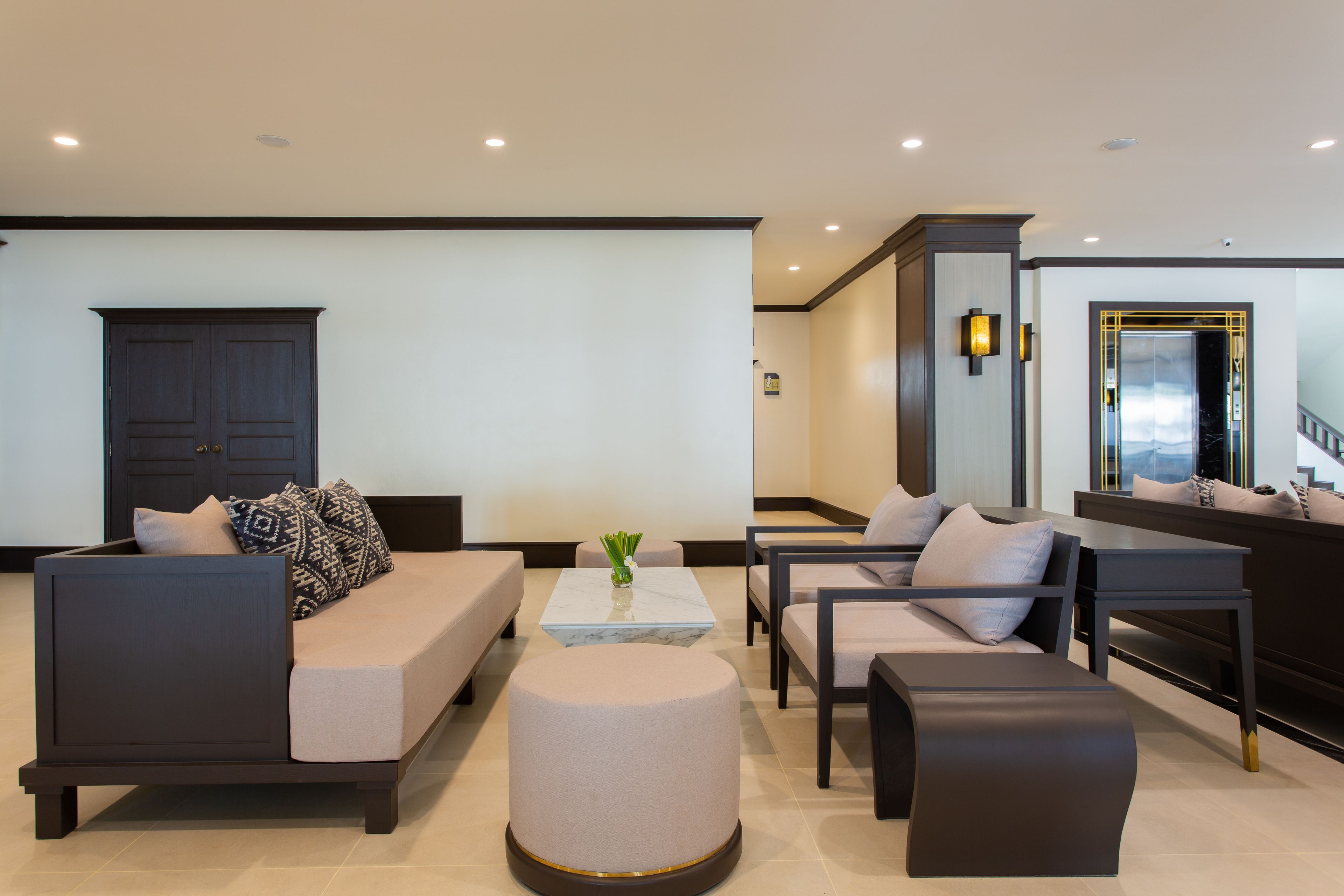 A modern living room with a sofa set, ottoman, and a coffee table.