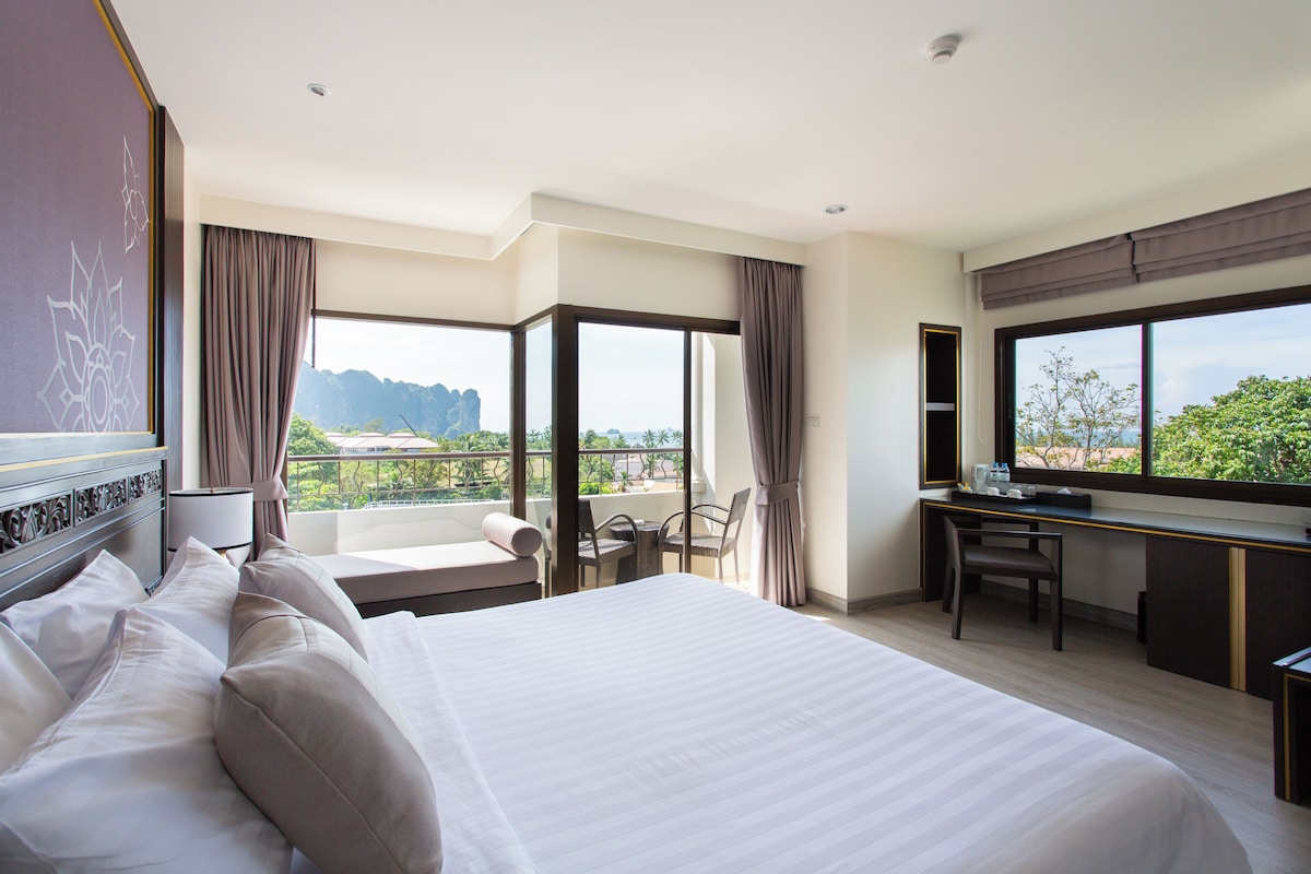 Une chambre d’hôtel avec un grand lit, un bureau et une vue sur les montagnes.