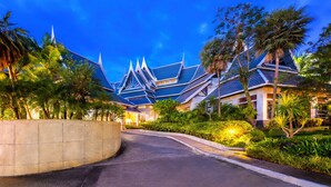 A modern resort with traditional architecture, a curved driveway, and lush greenery. - Chada Thai Village (Krabi)