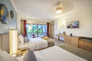 A hotel room with two beds, a desk, and a balcony with a view of palm trees. - Chada Thai Village (Krabi)