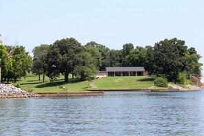 A lakeside property with a building, grassy areas, and trees. - Kenlake State Resort Park (Hardin)
