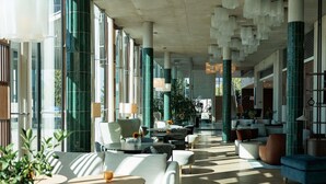 A spacious lobby with modern furniture, large windows, and a high ceiling with hanging light fixtures. - Mercure Tallinn (Tallinn)