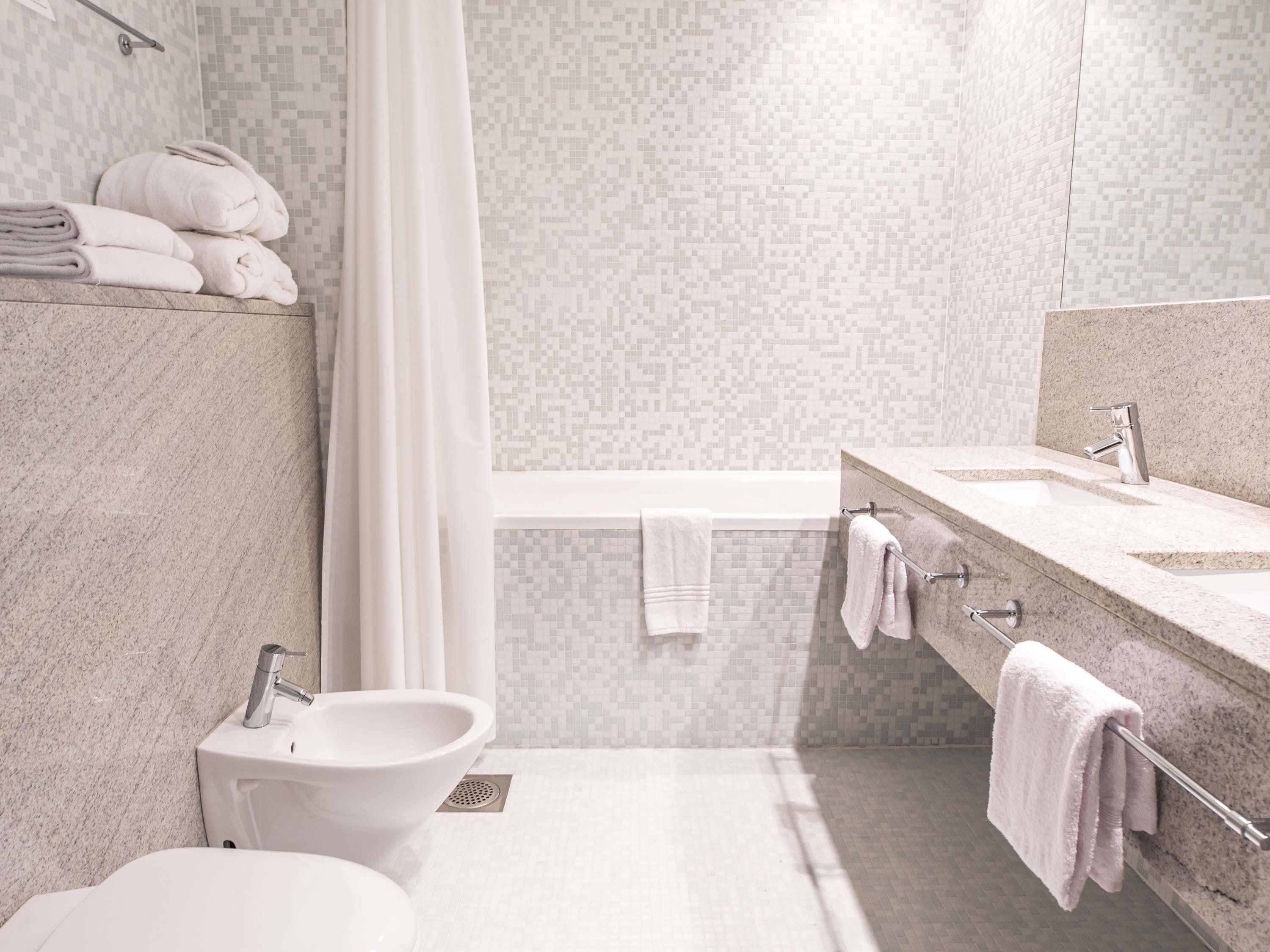 Ein modernes Badezimmer mit einer Bidet, einem Waschbecken und einer Badewanne.